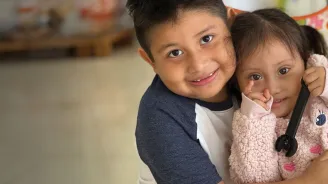 a boy hugging his sister