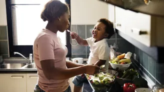 A mom prepares a meal for her family with the help of her toddler. 