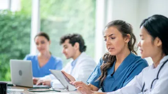 A Resident Speaks with Another Doctor About a Document.