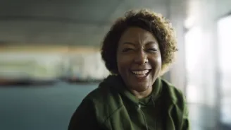 A smiling woman in a large empty room