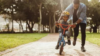 A father teaching his child how to ride a bike.