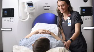 Radiologist reassures patient before imaging procedure.