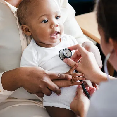 Doctor listening to baby's heartbeat with stethoscope