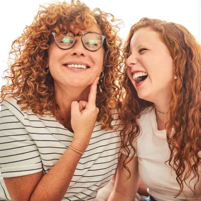 A mother and daughter joking and laughing together.