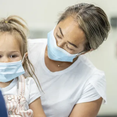 A mother at the doctor's office with her daughter.