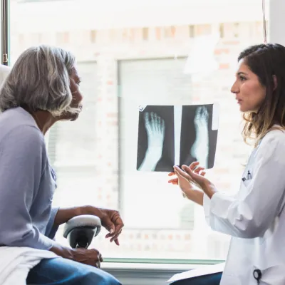 A patient and physician looking at foot x-rays