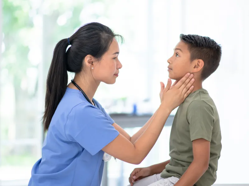 A Physcian Examines a Pediatric Patient's Neck