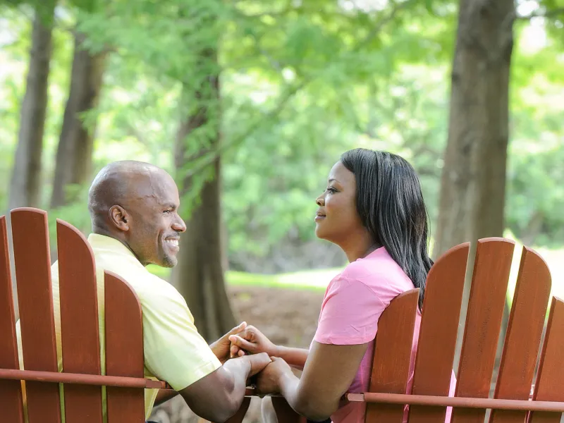 Couple Holding Hands And Sitting Together.