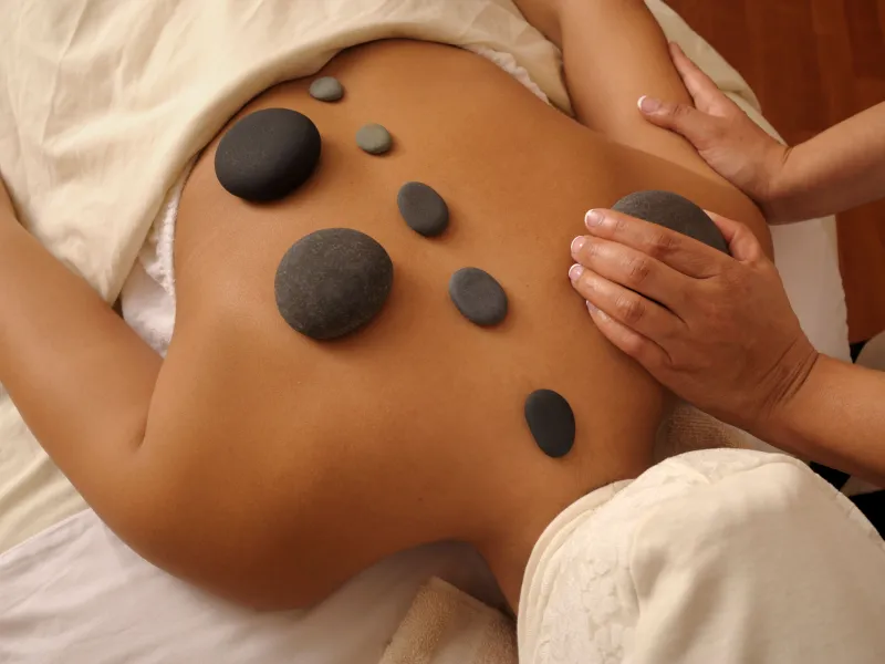 Woman getting a hot rock massage.