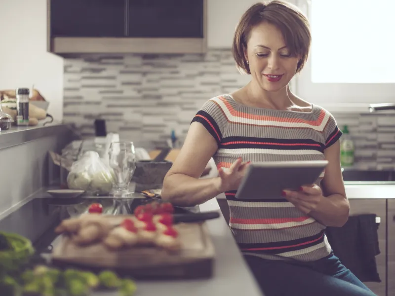 woman in kitchen reading tablet