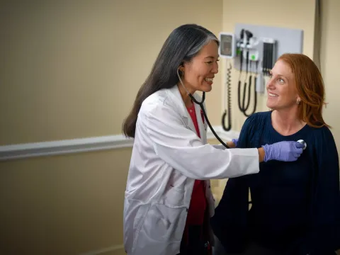 A Provider Checks Her Patient's Vitals in an Exam Room
