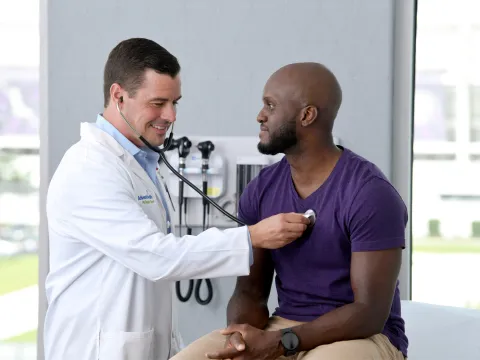A Provider Checks a Patient's Heart in an Exam Room