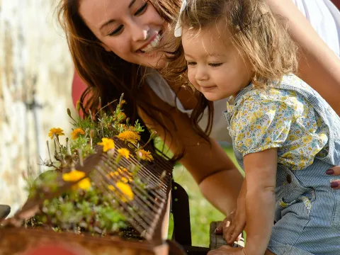 Mother and daughter smelling flowers. 