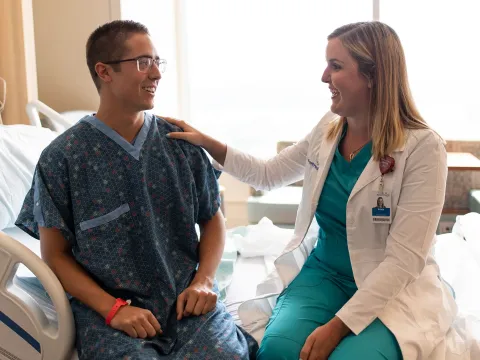 Doctor visits her patient in his room and reassures him.