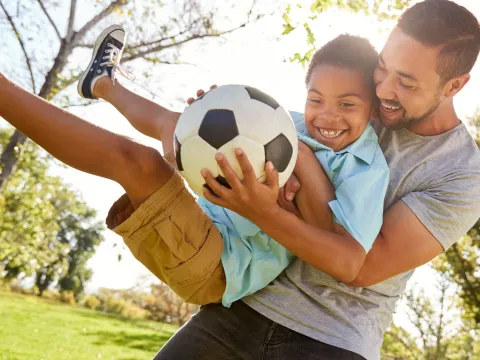 Father and Son with Soccer Ball outdoors