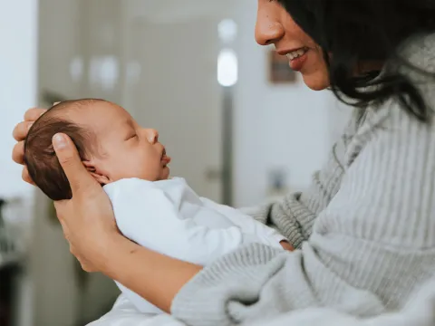 A mom holds her newborn infant. 