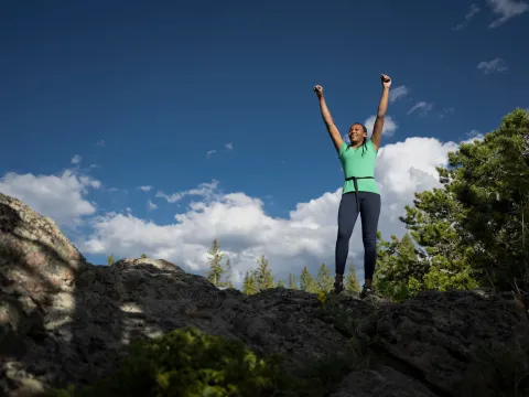 Woman on top of cliff.