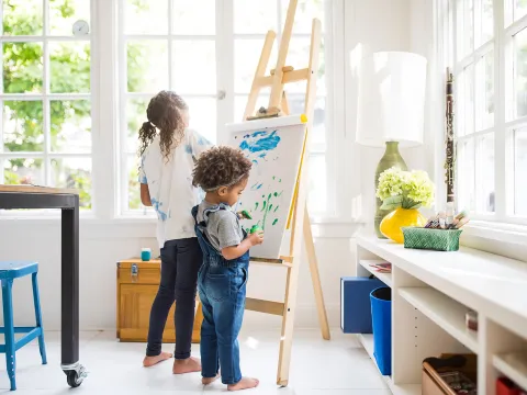 Two little girls painting a canvas in the craft room.