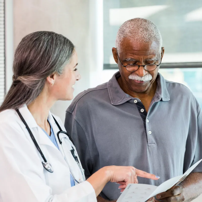 A Physician Goes Over a Chart with a Patient 