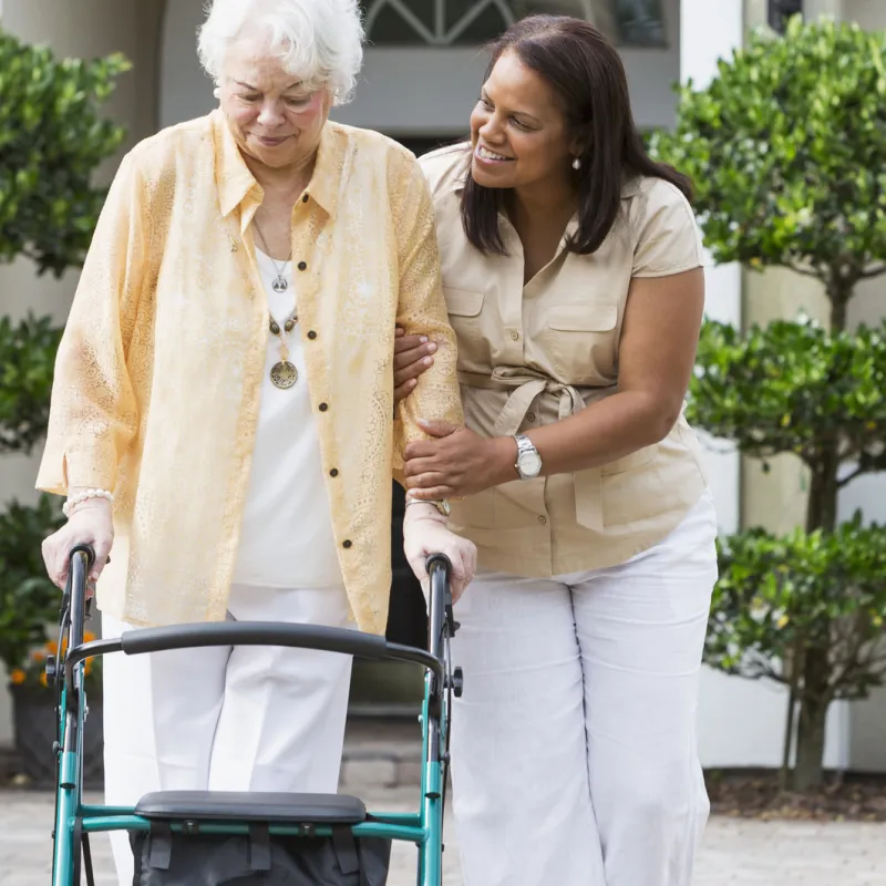 Woman in her driveway using a walker